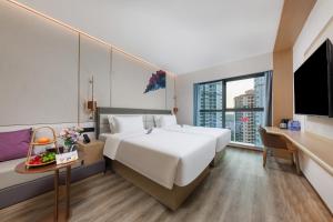 Habitación de hotel con cama grande y escritorio. en Elong Hotel Shenzhen South China City, en Shenzhen