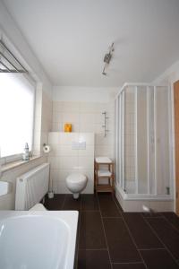 La salle de bains blanche est pourvue de toilettes et d'un lavabo. dans l'établissement K 97 - stilvolles Ferienhaus mit Kamin & WLAN am See in Röbel an der Müritz, à Röbel