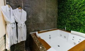 ein Badezimmer mit einer weißen Badewanne und einer grünen Wand in der Unterkunft Best Western Premier Ark Hotel in Tirana