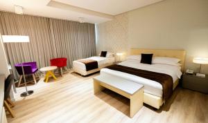 a hotel room with two beds and a table and chairs at Best Western Premier Ark Hotel in Tirana