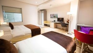 a hotel room with two beds and a desk at Best Western Premier Ark Hotel in Tirana