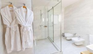 a white bathroom with a shower and a toilet at Best Western Premier Ark Hotel in Tirana