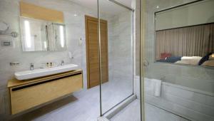 a bathroom with a sink and a shower at Best Western Premier Ark Hotel in Tirana