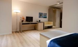 a bedroom with a bed and a desk with a television at Best Western Premier Ark Hotel in Tirana