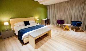 a bedroom with a bed and two chairs and a table at Best Western Premier Ark Hotel in Tirana