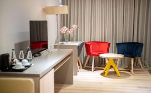 a room with two chairs and a desk with a television at Best Western Premier Ark Hotel in Tirana
