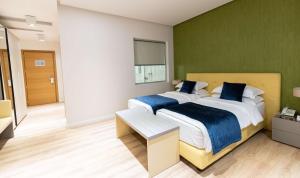 two beds in a bedroom with green walls at Best Western Premier Ark Hotel in Tirana