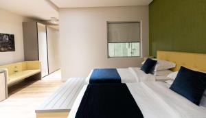 two beds in a room with green and white at Best Western Premier Ark Hotel in Tirana