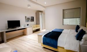 a bedroom with a bed and a flat screen tv at Best Western Premier Ark Hotel in Tirana