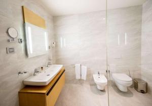 a white bathroom with a sink and a toilet at Best Western Premier Ark Hotel in Tirana