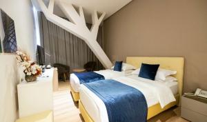 a bedroom with two beds with blue pillows at Best Western Premier Ark Hotel in Tirana