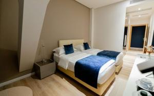 a bedroom with a large bed with blue pillows at Best Western Premier Ark Hotel in Tirana