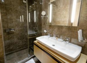 a bathroom with a sink and a shower at Best Western Premier Ark Hotel in Tirana