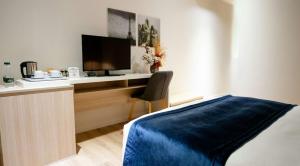 a bedroom with a desk with a television and a bed at Best Western Premier Ark Hotel in Tirana