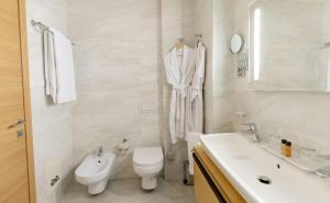 a white bathroom with a toilet and a sink at Best Western Premier Ark Hotel in Tirana