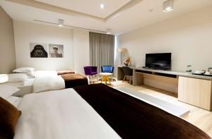 a hotel room with two beds and a flat screen tv at Best Western Premier Ark Hotel in Tirana