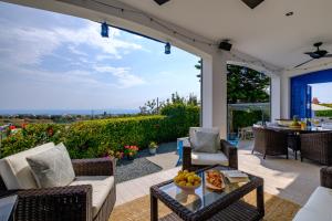eine Terrasse mit einem Tisch und Stühlen mit Aussicht in der Unterkunft Azure Luxury Villa by Nomads in Peyia