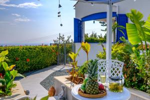 eine Terrasse mit einem Tisch mit Obst und einem Sonnenschirm in der Unterkunft Azure Luxury Villa by Nomads in Peyia