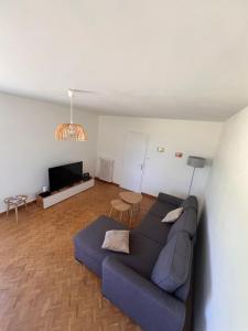 a living room with a couch and a table at A 30 min de l'île aux Mimosa Maison Vendéenne avec Jardin in Sallertaine
