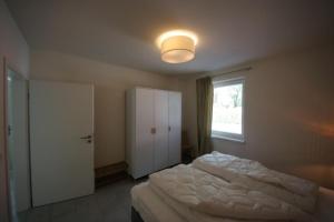 a bedroom with a white bed and a window at K 100 EG - Ferienwohnung im Erdgeschoss mit großem Garten in Röbel