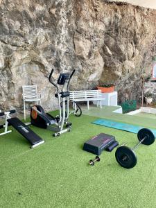 a gym with a treadmill and exercise equipment in front of a stone wall at Beach hideaway apartment with modernist design in Santa Cruz de Tenerife