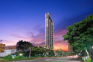 un edificio alto al anochecer en Elong Hotel Shenzhen South China City, en Shenzhen