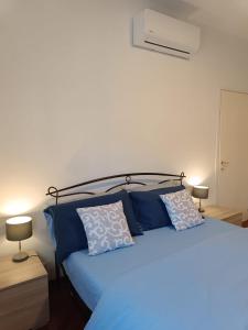 una camera con letto blu e cuscini blu di Appartamento Milano, Bovisa Politecnico, Dergano metropolitana, Wifi - Garden a Milano