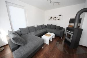 a living room with a couch and a stove at K 94 - Stilvolles Ferienhaus mit Kamin in Roebel an der Mueritz in Marienfelde