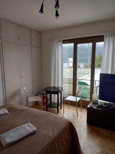 1 dormitorio con cama, mesa y TV en House1919 Via Valmara 14, en Brissago