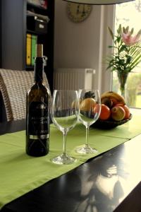 eine Flasche Wein und zwei Weingläser auf dem Tisch in der Unterkunft K 104 EG - moderne Ferienwohnung am See mit Sauna & Kamin in Marienfelde