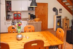 uma cozinha com uma mesa de madeira com um vaso de flores em 2 - Schönes Ferienhaus für die ganze Familie direkt an der Müritz em Marienfelde