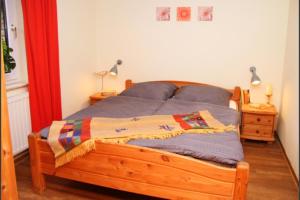 uma cama com uma estrutura de madeira num quarto em 2 - Schönes Ferienhaus für die ganze Familie direkt an der Müritz em Marienfelde
