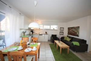 a living room with a table and a couch at 44 EG - Ferienwohnung mit Terrasse und Seeblick in Röbel