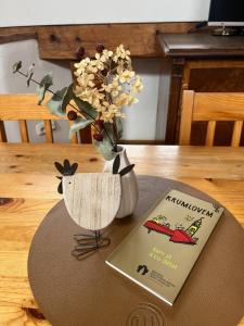 una mesa con un libro y un jarrón con flores en Travel Hostel, en Český Krumlov