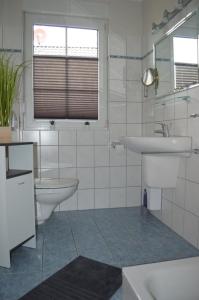 Marienfeldeにある7 EG - Charmante Ferienwohnung mit Seeblick & schoenem Garten in Röbel an der Müritzの白いバスルーム(洗面台、トイレ付)