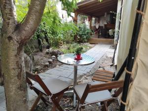 a patio with a table and chairs and a tree at Glamping Casa Soarelui in Vama Veche