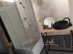 a shower in a bathroom with a mirror and a table at Glamping Casa Soarelui in Vama Veche