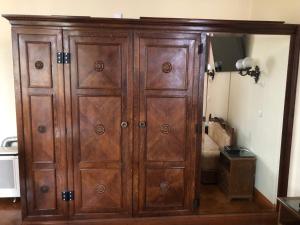 a large wooden cabinet in the corner of a room at Kalmár Panzió in Budapest