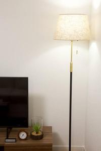 a lamp in a room with a tv and a clock at Lana Condo Naha in Naha