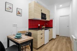 a kitchen with a table and a small kitchen with red tiles at Charming Chueca Center in Madrid