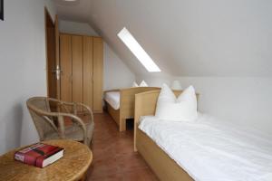 een slaapkamer met een bed en een tafel met een stoel bij 26 - Schoenes Ferienhaus mit Kamin fьr die ganze Familie direkt am See in Roebel in Röbel
