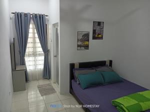 una camera con letto e finestra di Nur’s Homestay a Kuala Kelawang