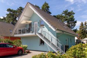 a red car parked in front of a house at K 102 OG - stilvolle Ferienwohnung an der Müritz in Röbel an der Müritz in Marienfelde