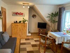 a living room with a table and a tv at Gasthaus Kienbaum 