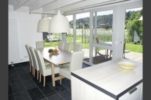 W9 - Traumhaftes Ferienhaus mit Kamin & grossem Garten in Roebel في Marienfelde: مطبخ وغرفة طعام مع طاولة وكراسي