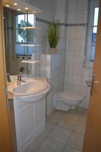 uma casa de banho com um lavatório e um WC em 7 OG - Charmante Ferienwohnung mit traumhaften Seeblick und Balkon in Röbel an der Müritz em Marienfelde
