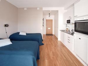 2 łóżka w małym pokoju z kuchnią w obiekcie Studio next to train station, 7 mins by train to airport w mieście Vantaa