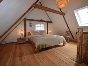 ein Schlafzimmer mit einem großen Bett im Dachgeschoss in der Unterkunft Ferienhaus Galerie No 5 in Garding