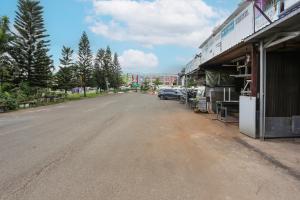 une rue vide avec une voiture garée à côté d'un bâtiment dans l'établissement OYO 93772 Iconiq Rooms, à Bekasi