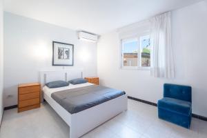 ein Schlafzimmer mit einem Bett und einem blauen Stuhl in der Unterkunft Chalet Itsaso in Canet d'en Berenguer